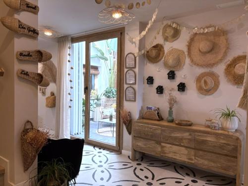 a room with straw hats on the wall and a wooden dresser at Montroig 5 hotel boutique in Sitges