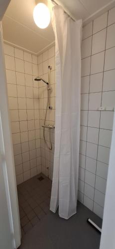 a bathroom with a shower with a white shower curtain at Dunopark Bungalow in Oostkapelle