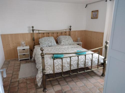 a bedroom with a bed with a metal frame at Gîtes de beaux rêves, Glycine in Uxeau