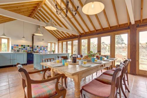 a kitchen and dining room with a wooden table and chairs at Williams Barn in West Beckham