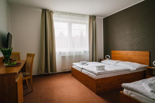 a hotel room with a bed and a window at Hotel Olympionik in Mělník