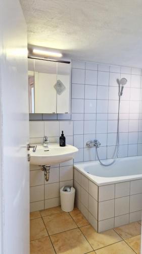 a bathroom with a sink and a bath tub at ARGENTA Living - QUELLQUARTIER in Fulda