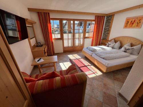 a living room with a bed and a couch at Hotel Garni Gafluna in Sankt Anton am Arlberg