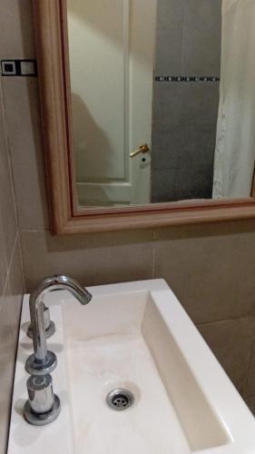 a white bathroom sink with a mirror and a sink at Lo de Lety in Baradero