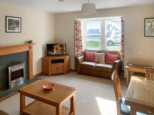 a living room with a couch and a fireplace at 1 Lonsdale House in Keswick