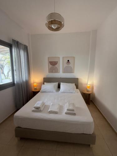 a bedroom with a white bed with two towels on it at Akti Rooms And Studios in Livadi