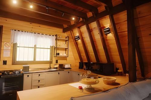 a kitchen with wooden walls and a table in a room at Alabama Cabin - Serra Gaúcha in Picada Cafe