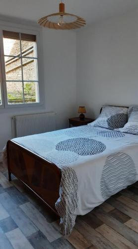 a bedroom with a large bed with a wooden floor at Dépendance du Duesmois in Fontaines-en-Duesmois