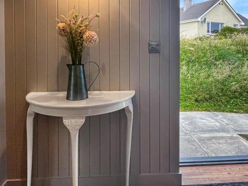 a vase on a table with flowers on it at Taigh Mullach Dearg in Portree