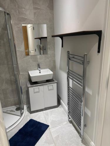 a bathroom with a sink and a shower at Queens apartments Belfast in Belfast