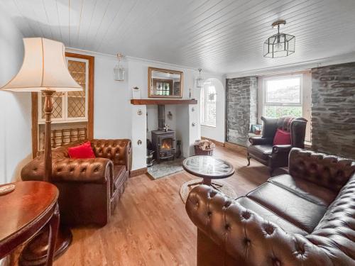 a living room with leather furniture and a fireplace at Croftbank in Lochranza