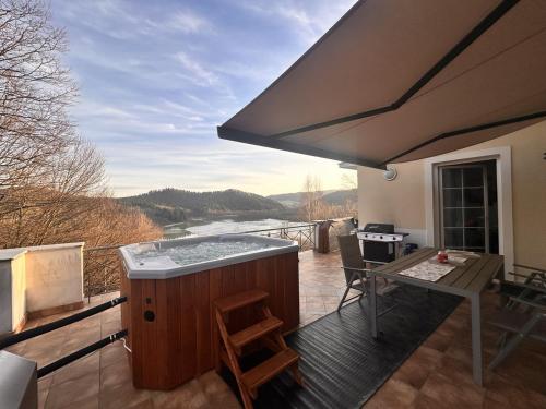 a balcony with a hot tub and a kitchen with a view at WołkoWilla - Willa z Jacuzzi na wyłączność MEGA WIDOK ! in Polańczyk