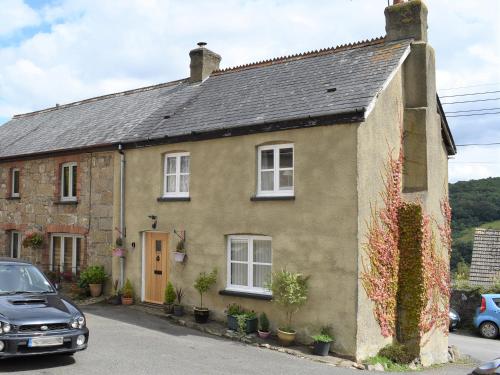 a house with a car parked in front of it at Scenery Cottage in Bridford