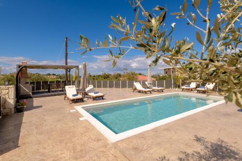 a swimming pool with chairs and a gazebo at Athenia Apartments in Vasilikos