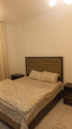a bedroom with a bed and two night stands at Oasis TOWER 1105 in Ajman 