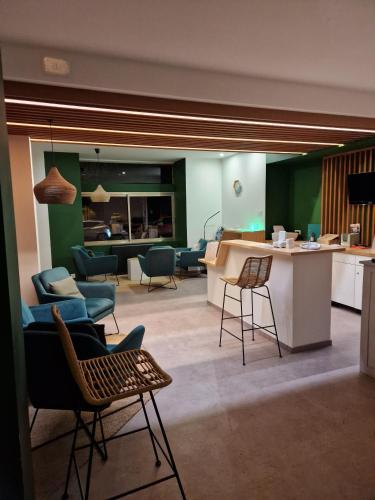a living room with chairs and a counter in a room at Phenix Hôtel Limoges in Limoges