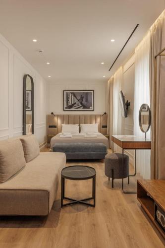 a bedroom with a bed and a couch and a table at Mouragia by Kantoni in Corfu