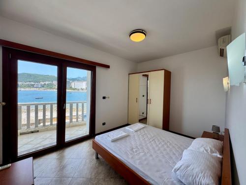 a bedroom with a bed and a large window at Lighthouse Rafailovići, Budva in Rafailovici