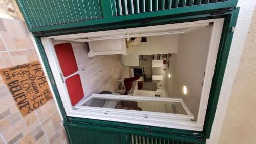 a large window in a green door of a room at House Maja in Jadrija