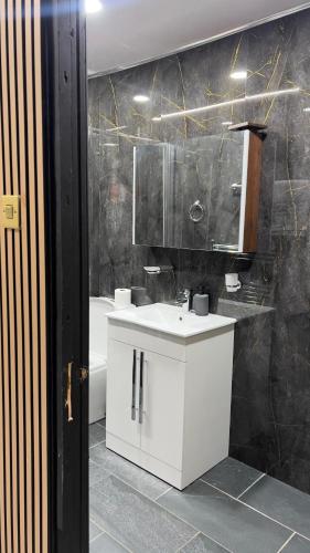 a bathroom with a white sink and a mirror at Luxury rooms in Ashton under Lyne