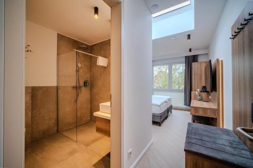 a bathroom with a shower and a bed in a room at MSLiving Hotels in Hannover