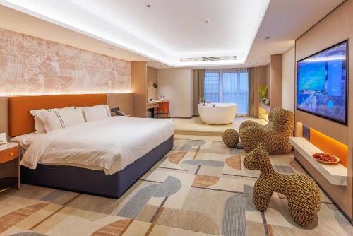 a bedroom with a large bed and a bathroom with a tub at Argyle Waifiden Hotel in Guangzhou