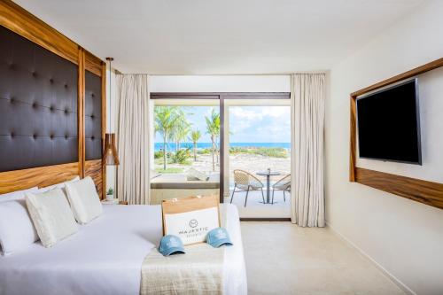 a hotel room with a bed and a view of the ocean at Majestic Mirage Costa Mujeres, All Suite Resort - All Inclusive in Cancún