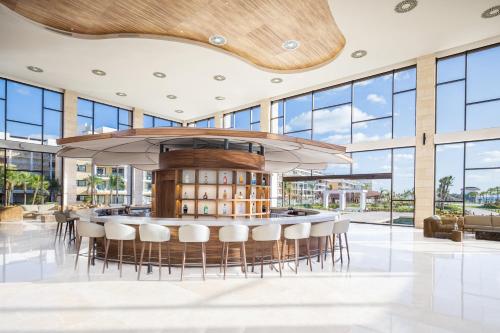 a large lobby with a bar with chairs and windows at Majestic Mirage Costa Mujeres, All Suite Resort - All Inclusive in Cancún