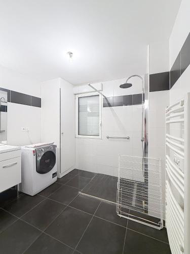 a white bathroom with a washing machine in it at Les Sables 4 in Fort-Mahon-Plage