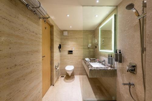 a bathroom with a toilet and a sink and a shower at Lords Plaza Surat in Surat