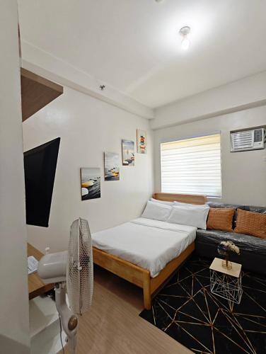 a bedroom with a bed and a couch at R&N Trees Residence in Manila