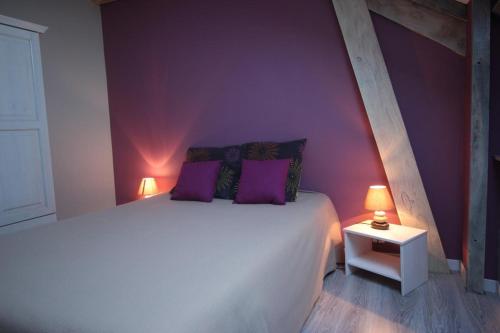 a bedroom with a large bed with purple walls at Amboiras in La Croisille-sur-Briance