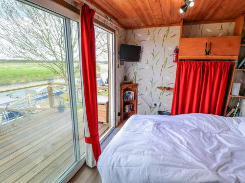 a bedroom with a bed and a sliding glass door at Riverside Cabin in Peterborough