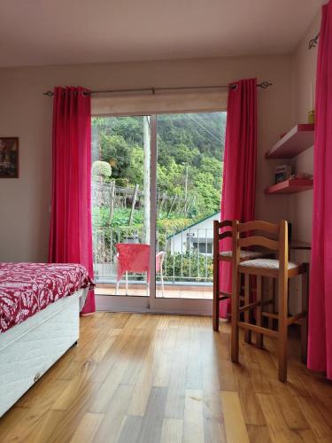 ein Schlafzimmer mit rosa Vorhängen und einem Bett und einem Fenster in der Unterkunft Oceanview room in Ponta Delgada