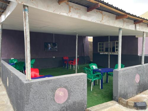 a patio with colorful chairs and tables on the grass at FE Purple Gold Hotel in Abuja
