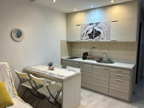 a kitchen with a sink and a table with chairs at Relax Apartment in Vrnjačka Banja