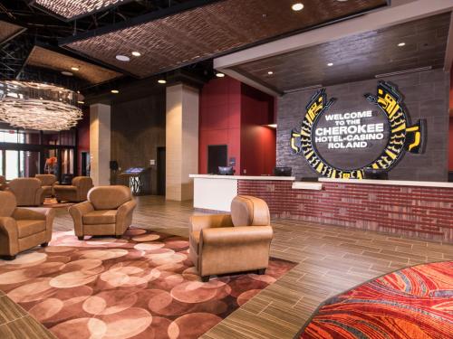 a lobby with chairs and a sign on the wall at Cherokee Casino Hotel Roland in Roland