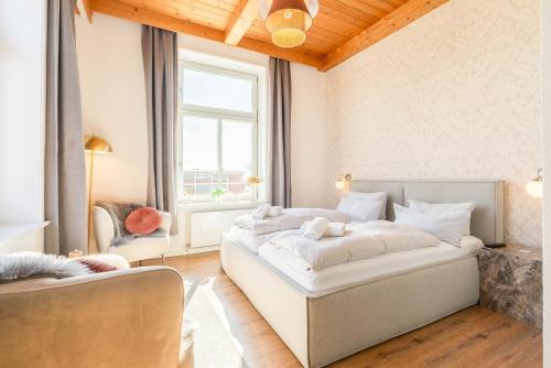 a bedroom with a large white bed and a window at Lexow - Hotel an de Havenkant in Tönning