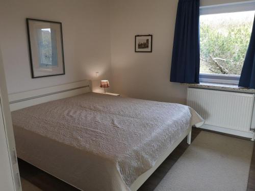 a bedroom with a bed and a window at RUeM-HART-I-Whg-2 in Hörnum