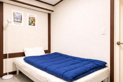 a room with a bed with a blue blanket on it at 더스테이365 스탠다드 in Seoul