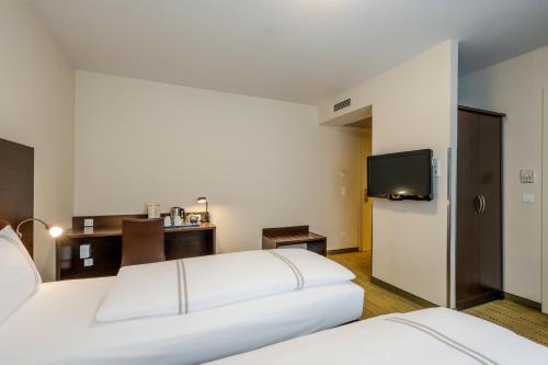 a hotel room with two beds and a flat screen tv at Premier Inn Berlin City Spittelmarkt in Berlin