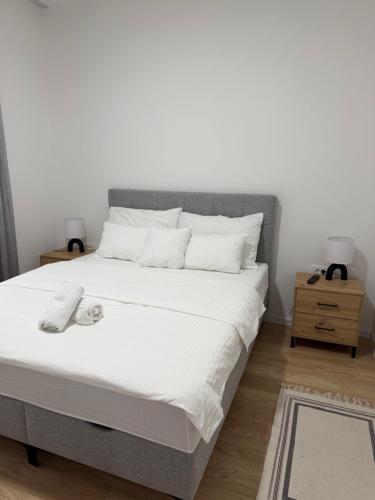 a bedroom with a large bed with white sheets at Apartmani Novak in Mostar