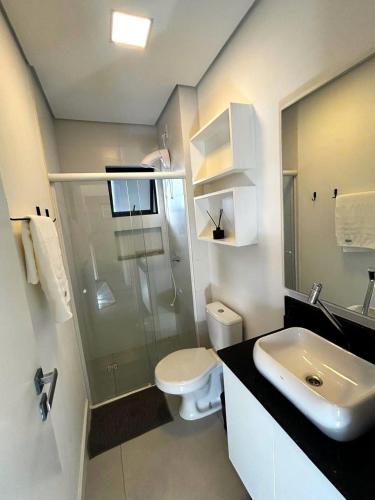 a bathroom with a shower and a toilet and a sink at RCM Vilas - Apartamento 306 in Joinville