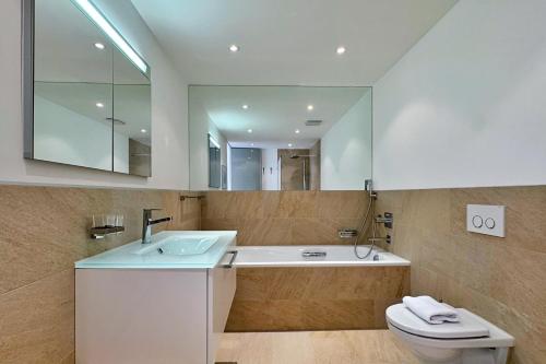 a bathroom with a sink and a toilet and a mirror at Eiger Residence 2 in Wengen