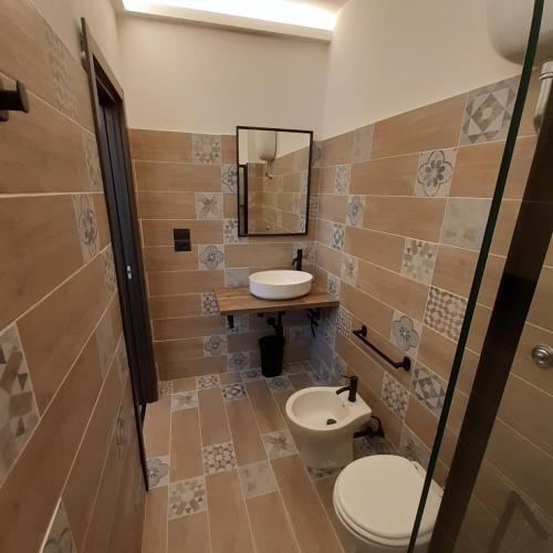 a bathroom with a toilet and a sink and a mirror at Angela's house in Sulmona