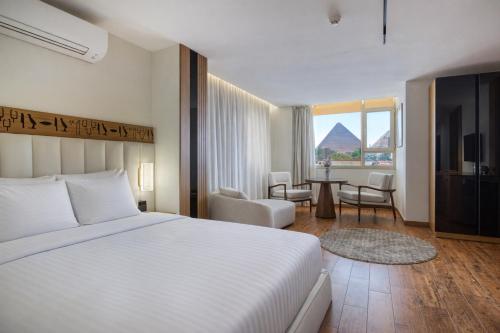 a hotel room with a bed and a table and chairs at Superior Pyramids View in Cairo