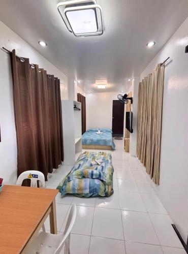 a room with a bed and a table and chairs at Private Room at MA Compound in Concepcion