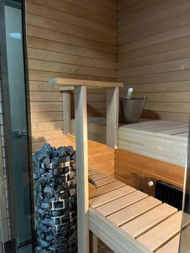 a sauna with a stack of logs next to a table at Casa de Fit in Joensuu