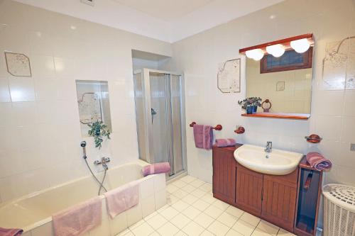 a bathroom with a sink and a shower and a tub at Casa Olaf in Cannobio
