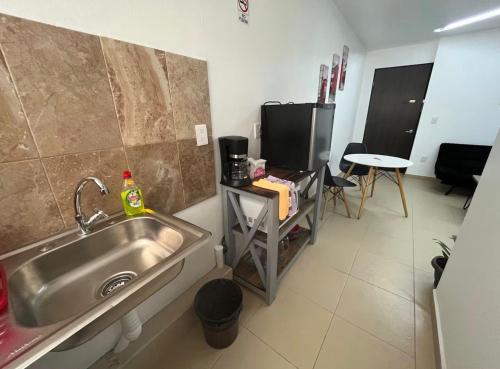 a kitchen with a stainless steel sink and a table at STUDiOS RAYON in Morelia